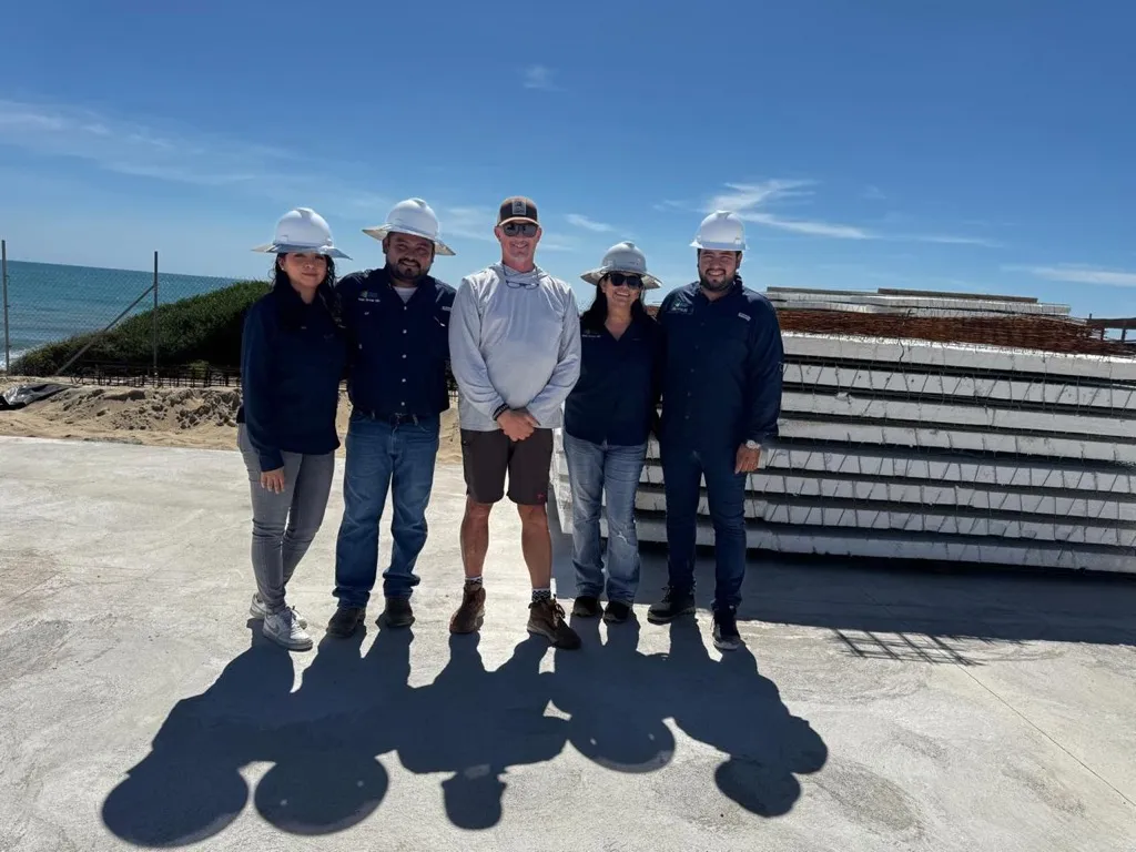 SDM Group team gathered at an oceanfront construction site